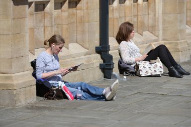 People sit on a city centre street enjoying a sunny day on May 3, 2016 in Bath, UK