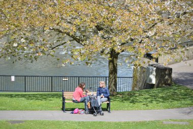women sitting on the bench in the park on May 3, 2016 in Bath, UK
