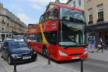 İkonik kırmızı bir tur otobüsü 13 Mayıs 2016 'da Bath, İngiltere' de şehir merkezinden yolcu taşıyor. Somerset 'in Bath kenti her yıl 4 milyon turist ağırlayan popüler bir seyahat merkezidir..