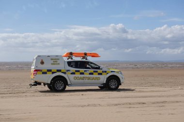 26 Haziran 2022 'de Weston-super-Mare, İngiltere' de bir sahil güvenlik devriyesi bir plajda devriye geziyor..