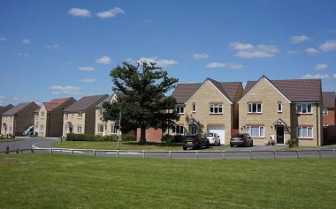 View of houses and green on a street in an English town