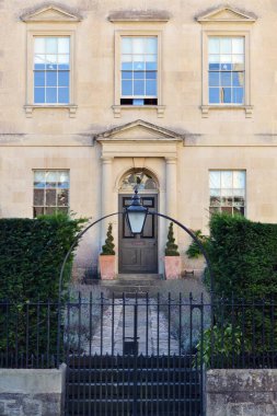 Exterior view and front door of a beautiful old townhouse on a street in an English city