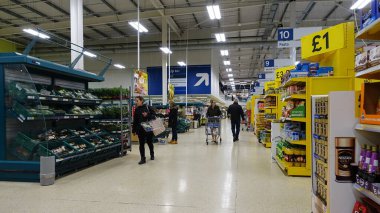 Müşteriler 4 Nisan 2019 'da Londra, İngiltere' de bir Tesco süpermarketinde bir koridora bakıyorlar. İngiliz Tesco, Amerika 'daki Walmart ve Fransız Carrefour' tan sonra dünyanın en büyük üçüncü süpermarket perakendecisi oldu..