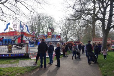 Bath, İngiltere - 7 Nisan 2019: İnsanlar Royal Victoria Park 'taki gezici bir lunaparkı ziyaret ediyor.