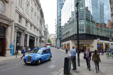İnsanlar 5 Haziran 2019 'da Londra' da bir cadde boyunca yürürler. Kentin bilinen adı İngiliz başkentinin finans bölgesidir ve buna karşılık dünyanın en büyük finans merkezlerinden biridir..