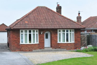 Bir İngiliz kasabasındaki bir sokağın dış görünüşü bir bungalov evi ve bahçesi.
