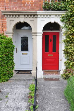 Bir İngiliz şehrinde, bir caddede iki komşu kasaba evinin ön kapıları.