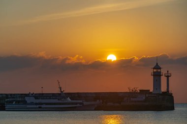 Güneş Yalta deniz fenerinin arkasından doğuyor.