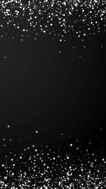 Yılbaşı arka planında rastgele beyaz noktalar. İnce uçan kar taneleri ve siyah arka plandaki yıldızlar. Takdire şayan kış gümüşü kar tanesi şablonu örtüyor. Şaşırtıcı dikey çizim.