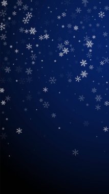 Az kar yağan Noel arkaplanı. İnce uçan kar taneleri ve koyu mavi arka plandaki yıldızlar. İnanılmaz kış gümüşü kar taneleri şablonu örtüyor. Büyüleyici dikey çizim.