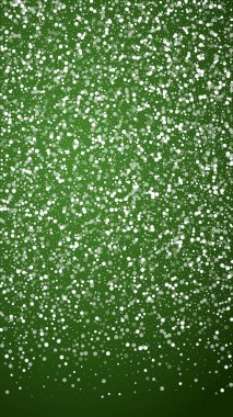 Yılbaşı arka planında kar yağışı var. İnce uçan kar taneleri ve yeşil arka plandaki yıldızlar. Karlı bayram örtüsü. Dikey vektör illüstrasyonu.