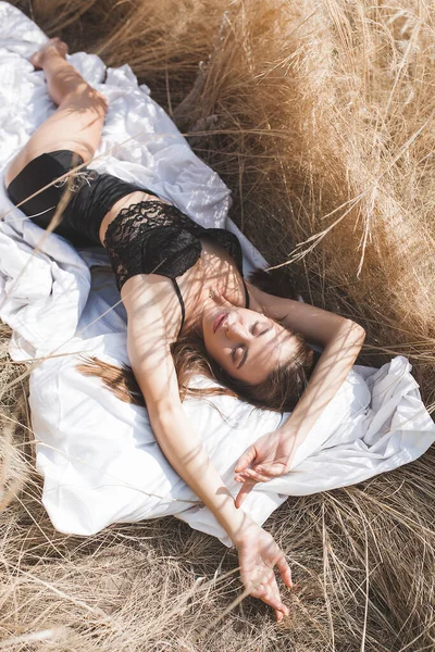 Beyaz çarşafların üzerinde çekici genç kadınlar. Dışarıda beyaz çarşaflarla uyuyan güzel bir kadın..