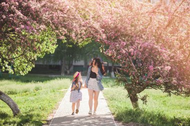 Genç anne ve küçük tatlı kızı dışarıda eğleniyorlar. Aile kızları bir arada.