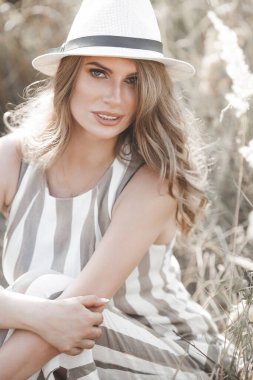 Şapkalı genç ve çekici bir kadın. Açık havada güzel bir kadının yakın plan portresi. Güzel bayan gülümsüyor