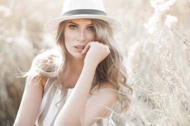 Young attractive woman in the hat. Closeup portrait of beautiful woman outdoors. Pretty lady smiling