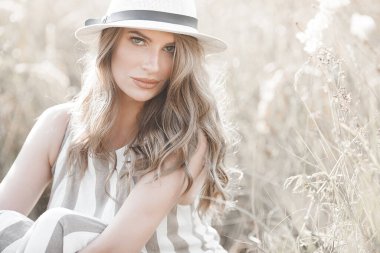 Young attractive woman in the hat. Closeup portrait of beautiful woman outdoors. Pretty lady smiling