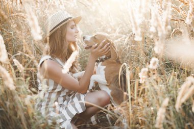 Açık havada evcil hayvanıyla çekici bir genç kadın. Sahibi ve köpeği birlikte. Sonsuza dek arkadaşız. Bayan ve Beagle.