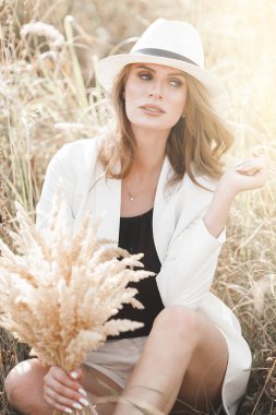 Şapkalı genç ve çekici bir kadın. Açık havada güzel bir kadının yakın plan portresi. Güzel bayan gülümsüyor