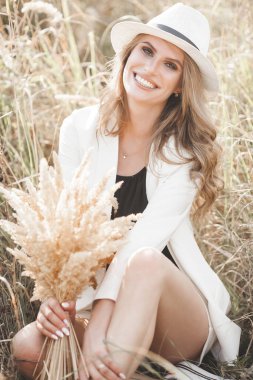 Young attractive woman in the hat. Closeup portrait of beautiful woman outdoors. Pretty lady smiling