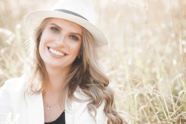 Young attractive woman in the hat. Closeup portrait of beautiful woman outdoors. Pretty lady smiling