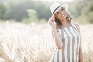 Şapkalı genç ve çekici bir kadın. Açık havada güzel bir kadının yakın plan portresi. Güzel bayan gülümsüyor