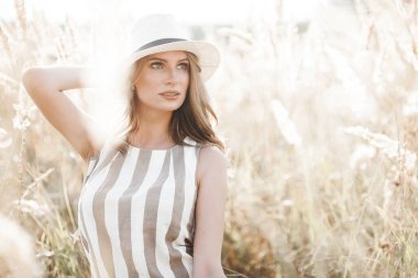 Young attractive woman in the hat. Closeup portrait of beautiful woman outdoors. Pretty lady smiling