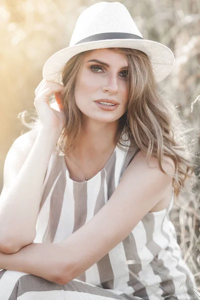 Şapkalı genç ve çekici bir kadın. Açık havada güzel bir kadının yakın plan portresi. Güzel bayan gülümsüyor
