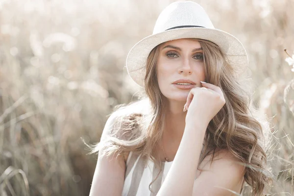 Şapkalı genç ve çekici bir kadın. Açık havada güzel bir kadının yakın plan portresi. Güzel bayan gülümsüyor