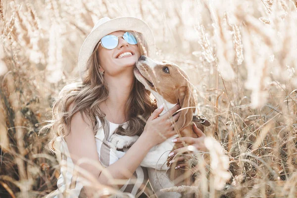 Açık havada evcil hayvanıyla çekici bir genç kadın. Sahibi ve köpeği birlikte. Sonsuza dek arkadaşız. Bayan ve Beagle.