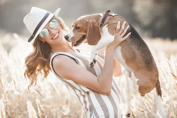 Açık havada evcil hayvanıyla çekici bir genç kadın. Sahibi ve köpeği birlikte. Sonsuza dek arkadaşız. Bayan ve Beagle.