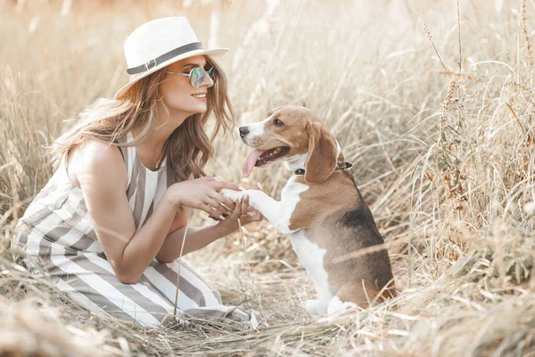 Açık havada evcil hayvanıyla çekici bir genç kadın. Sahibi ve köpeği birlikte. Sonsuza dek arkadaşız. Bayan ve Beagle.