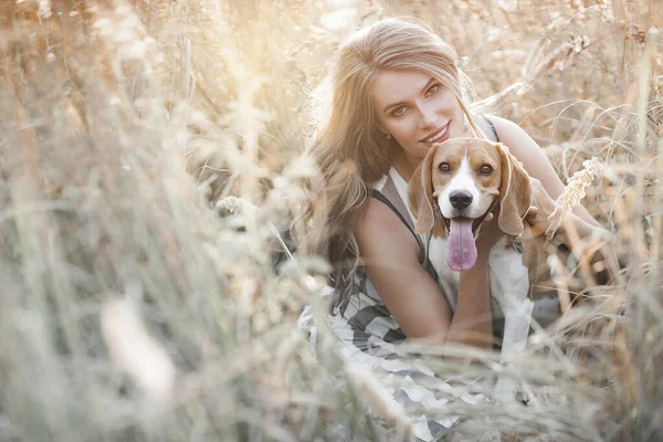Açık havada evcil hayvanıyla çekici bir genç kadın. Sahibi ve köpeği birlikte. Sonsuza dek arkadaşız. Bayan ve Beagle.