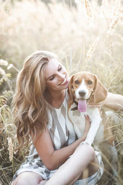 Açık havada evcil hayvanıyla çekici bir genç kadın. Sahibi ve köpeği birlikte. Sonsuza dek arkadaşız. Bayan ve Beagle.