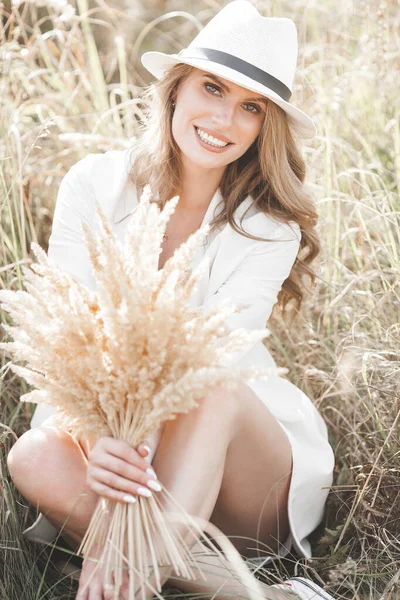 Şapkalı genç ve çekici bir kadın. Açık havada güzel bir kadının yakın plan portresi. Güzel bayan gülümsüyor