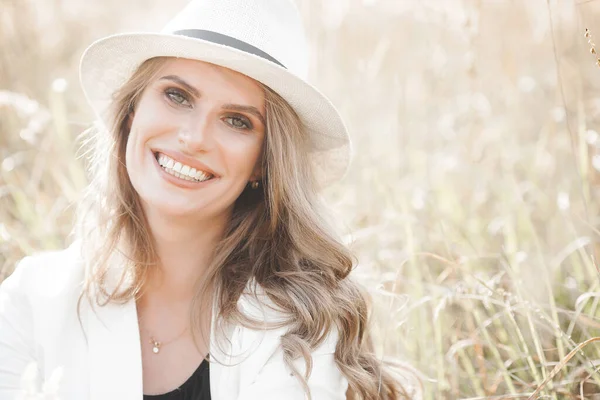 Şapkalı genç ve çekici bir kadın. Açık havada güzel bir kadının yakın plan portresi. Güzel bayan gülümsüyor