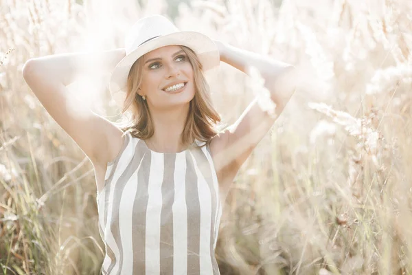 Şapkalı genç ve çekici bir kadın. Açık havada güzel bir kadının yakın plan portresi. Güzel bayan gülümsüyor