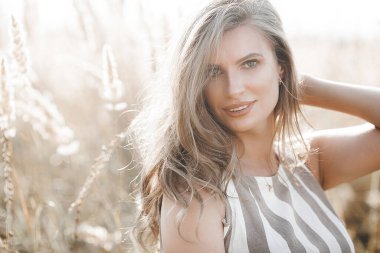 Beautiful blond woman closeup portrait outdoors. Smiling face. Lovely lady at summer background. Emotional female outdoors.