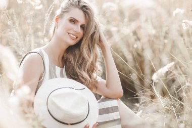 Güzel sarışın kadın, açık havada yakın plan portresi. Gülen surat. Yaz arkaplanındaki güzel bayan. Açık havada duygusal bir kadın.