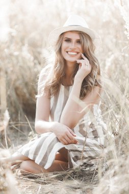 Şapkalı genç ve çekici bir kadın. Açık havada güzel bir kadının yakın plan portresi. Güzel bayan gülümsüyor