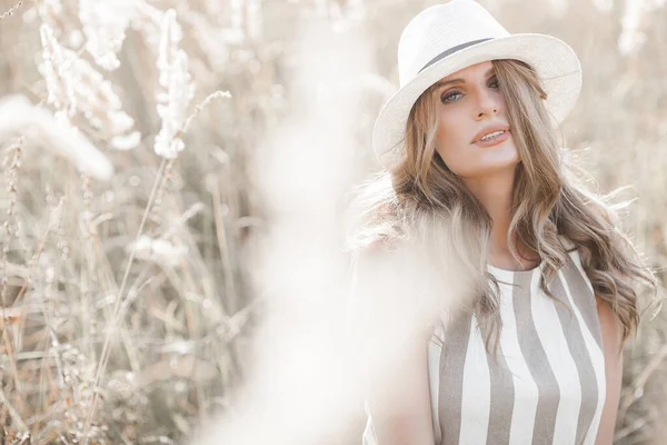 Şapkalı genç ve çekici bir kadın. Açık havada güzel bir kadının yakın plan portresi. Güzel bayan gülümsüyor