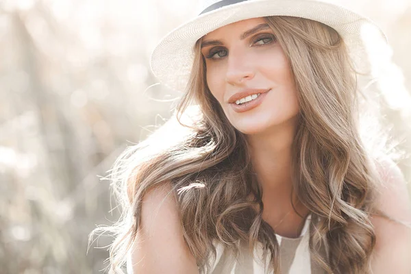 Şapkalı genç ve çekici bir kadın. Açık havada güzel bir kadının yakın plan portresi. Güzel bayan gülümsüyor