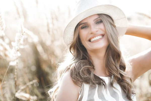 Young attractive woman in the hat. Closeup portrait of beautiful woman outdoors. Pretty lady smiling