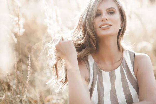 Güzel sarışın kadın, açık havada yakın plan portresi. Gülen surat. Yaz arkaplanındaki güzel bayan. Açık havada duygusal bir kadın.