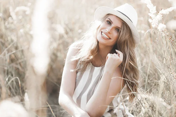 Şapkalı genç ve çekici bir kadın. Açık havada güzel bir kadının yakın plan portresi. Güzel bayan gülümsüyor