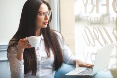 Kapalı alandaki genç bayanın yakın plan portresi. Kafeteryadaki kadın. Çekici esmer kadın..