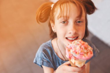 Kafeteryada dondurma yiyen tatlı küçük kız. Elinde dondurma tutan çocuk. Çocuk ve şekerler
