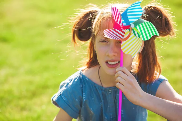 풍차를 다루는 재미있는 아가씨 풍차를 있는아이 여름의 — 스톡 사진