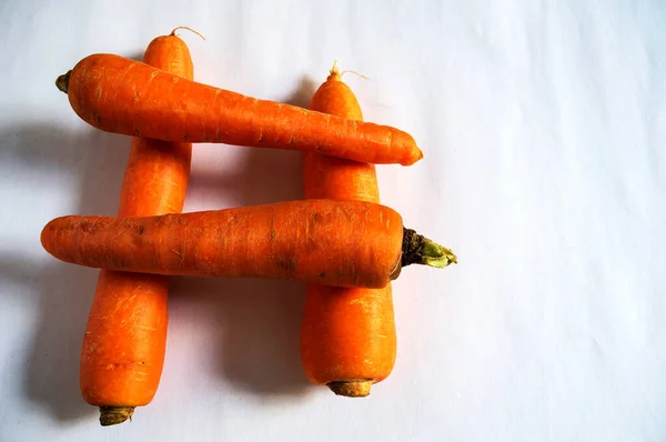 Four Whole Raw Carrots Stacked Forming Hashtag Symbol White Background — Stok Foto