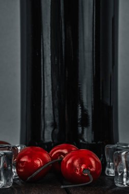 Bir sıra kırmızı kiraz ve buz. Bir şişe şarap.