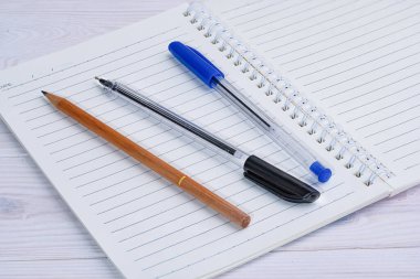 White notepad with lines and pencil and pens. High quality photo